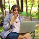 Happy freelancer sitting in garden and having video call on laptop - VideoHive Item for Sale