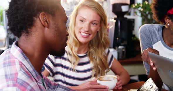 Friends interacting while having coffee alt