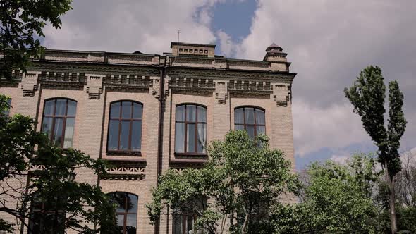 beautiful old brick building on the street with trees alt