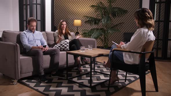 Wife Talking To Counselor While Man Using Phone alt