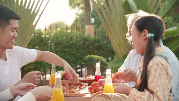 Asian retirement grandfather, pretty granddaughter, and parents enjoying eating pizza together alt