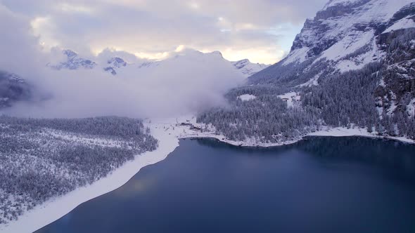 Oeschinensee Lake Switzerland Surrounded by Snow Covered Trees and Mountains alt