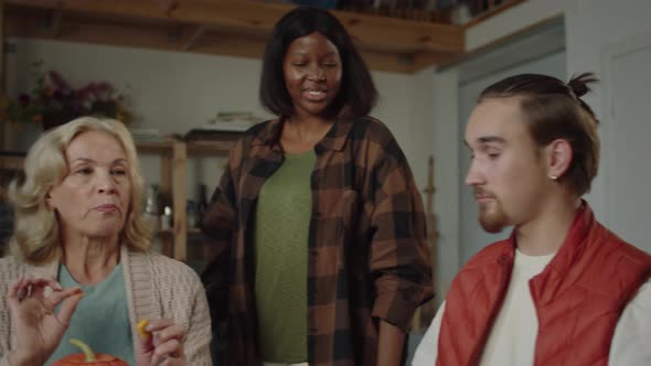 Young Woman Takes a Slice of Pumpkin From the Dinner Table and Tastes alt