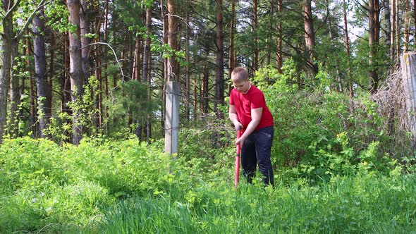 The Boy Mows the Green Grass with an Electric Trimmer alt