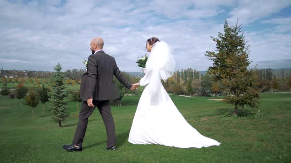 Newlyweds walking through a beautiful natural location holding hands