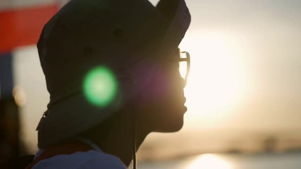 Young Asian woman traveler looking sunset beside river location Bangkok.