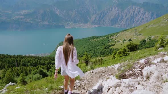 Tourist Girl Walks on the Rocky Mountain with Beautiful Landscape alt