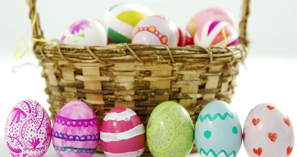 Basket with painted Easter eggs on white background alt