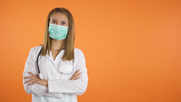 Portrait of Young Female Doctor with Medical Face Mask Holding Crossed Arms on Chest Isolated on alt
