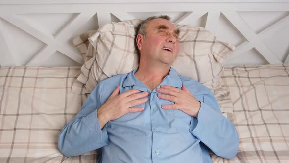 Portrait of Sick Aged Man Lying in Bed alt