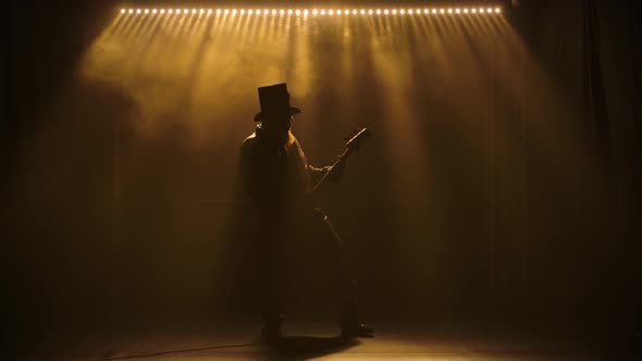 The Guitarist Performs on Stage. Slow Motion Performance. A Man in a Hat with a Beard Is alt
