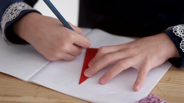 Cropped View of Kid's Hands Holding Pencil on Desk