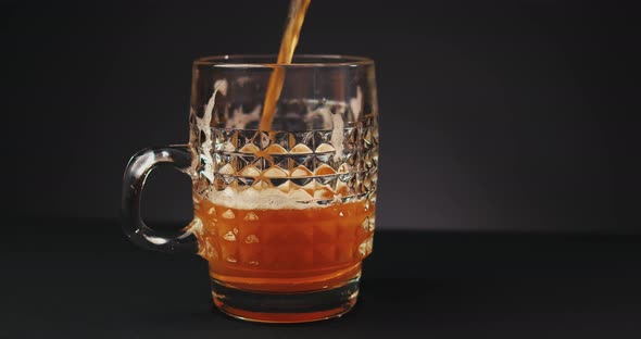 Pouring Beer Into Glass Over Dark Background alt