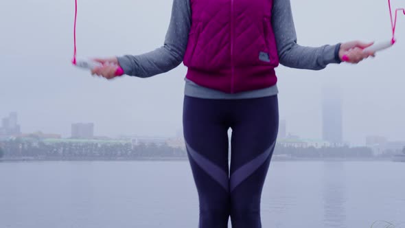 Slender Girl in Warm Sportswear is Jumping Rope alt