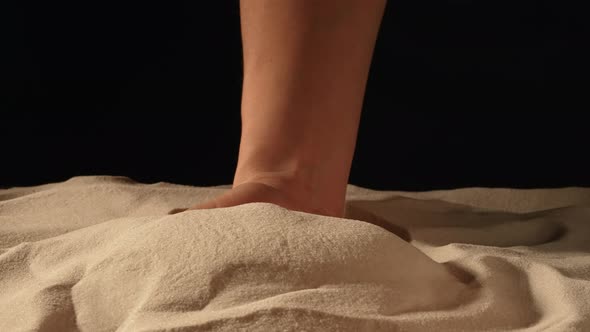 Woman with Handful of White Dry Sand in Her Hands Spilling Sand Through Her Fingers on Black Studio alt