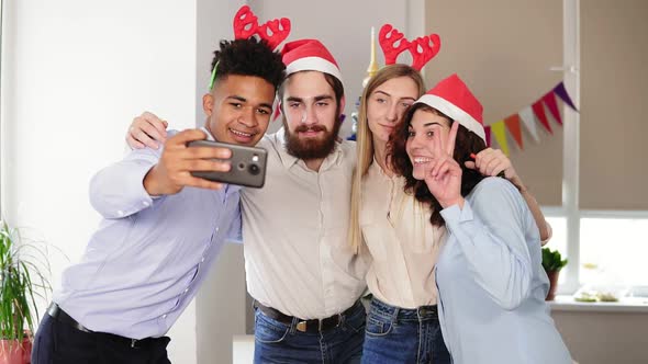 Happy Business People in Santa Hats are Doing Selfie and Smiling While Celebrating New Year in the alt