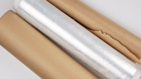 white transparent film for wrapping food and roll of brown craft paper