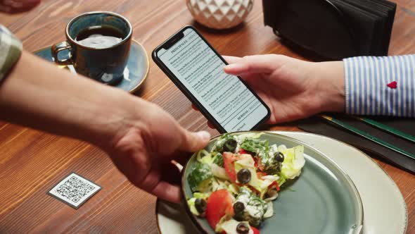 Woman Using Online Menu in Cafe Closeup Eating Vegetable Salad in Restaurant alt