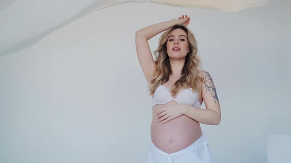 Luxurious Nude Pregnant Women Posing in Fashion Studio alt