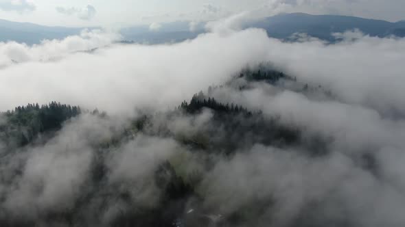 Slowly 180° over fog in mountains. Drone fly