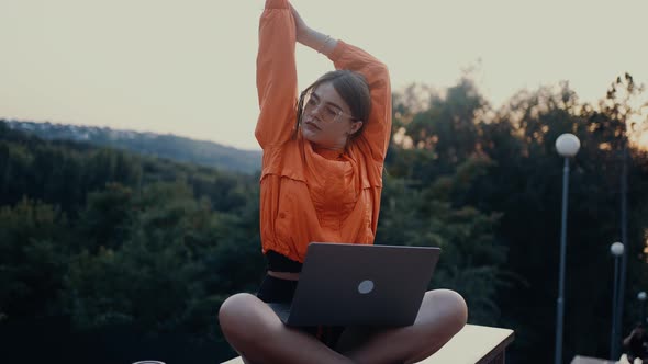 The Tired Young Student Takes a Break From Classes Raises Her Hands Stretches Then Turns to Face the alt