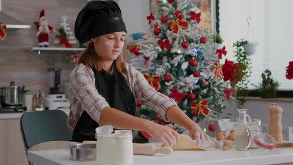 Portrait of Grandchild Wearing Apron Rolling Homemade Dough Using Rooling Pin alt