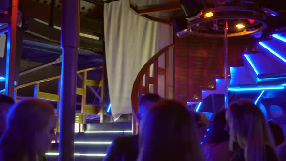 A group crowd of people dancing on the dance floor in a nightclub. alt