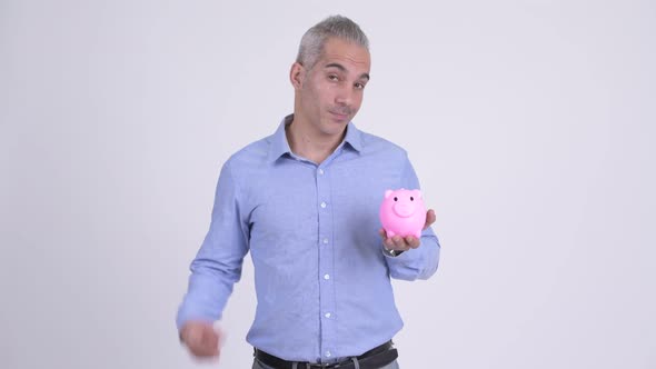 Happy Persian Businessman with Piggy Bank Giving Thumbs Up Against White Background alt