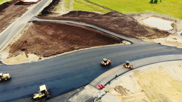 Aerial View of the Yellow Road Rollers That Lay the Asphalt of the Test Ground for Cars