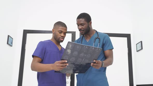 Young Doctors Looking At Computed Tomography Xray Image Discussing