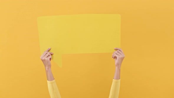 Woman hands holding speech bubble with empty space for text on yellow background