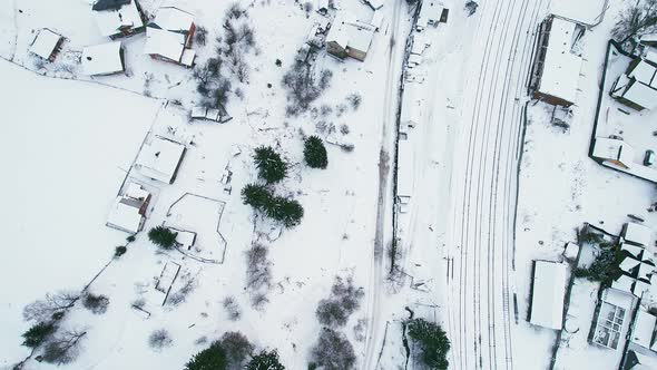 Top View of a Small Village with a Railway Station Covered in Snow