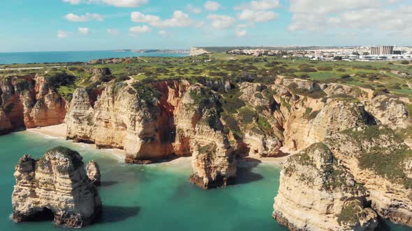 Algarve rocky eroded cliffs. Atlantic coast off Lagos, Portugal. Orbiting shot alt