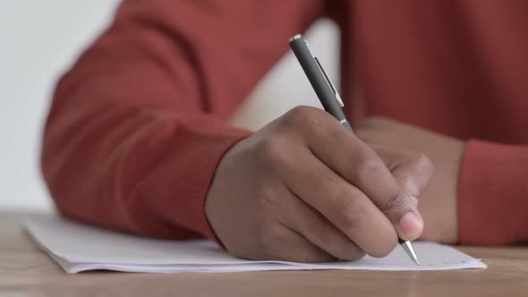 Hands Close up of African Man Writing on Paper alt
