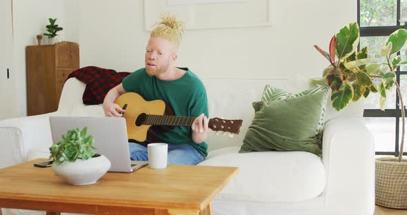 Albino african american man with dreadlocks playing guitars and singing alt