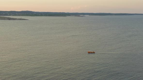 Boat Sailing Across Inlet Water In Store Torungen Island In Arendal, Norway. aerial alt
