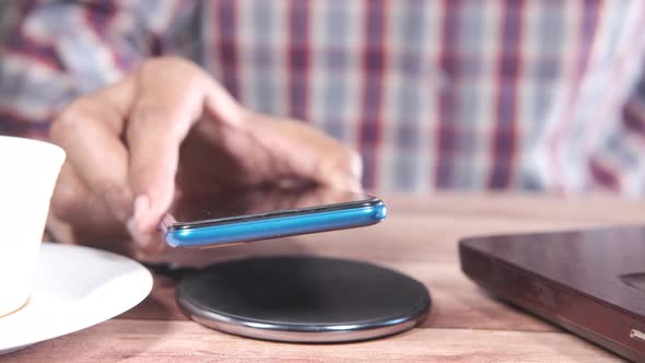 Charging Smartphone Using Wireless Charging Pad Top View alt