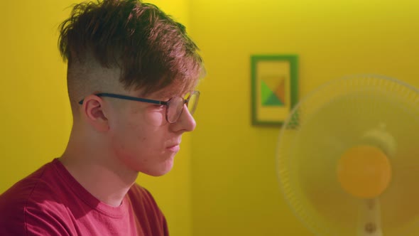 Young Man In Eyeglasses Is Working at Computer