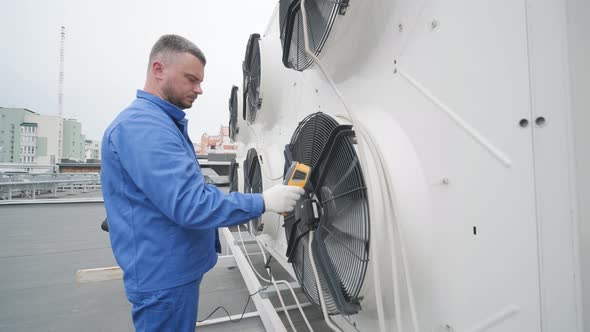 Technician uses a thermal imaging infrared thermometer to check the condensing alt