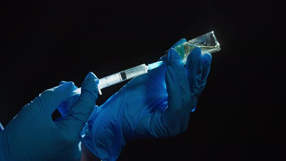 Doctor Filling Syringe with Solution on Black Background alt