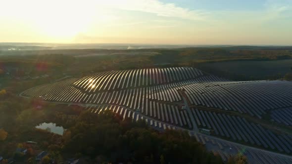 Aerial Drone Footage. Radial Flight Over Solar Panel Farm at Sunset Autumn Season