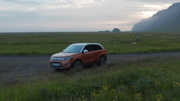 Slide and Pan Shot of Popular SUV Family Car Standing on Side of Dirt Road alt