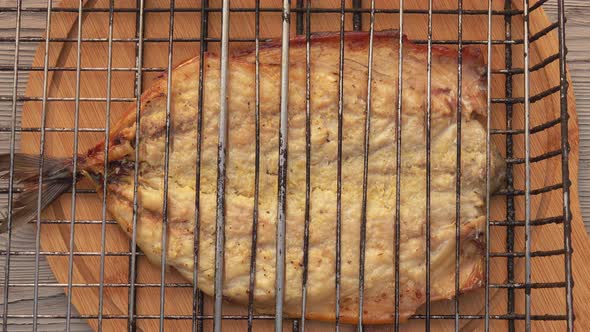 Top View of the Grill with Mackerel Fish Fillet Placed on the Round Wooden Board alt