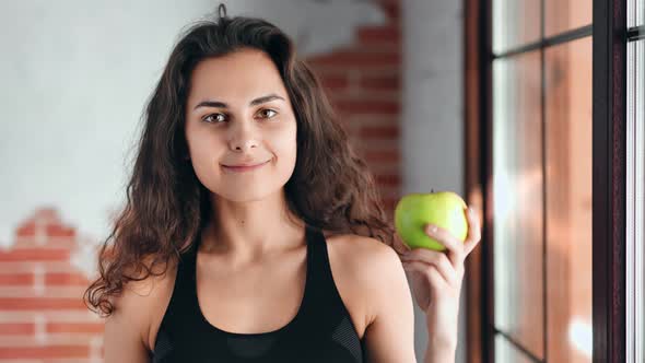 Medium Closeup Portrait of Happy Adorable Girl Holding Fresh Appetizing Green Apple alt