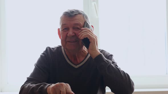 Elderly Man Dials Number and Speaks in Smartphone From Home