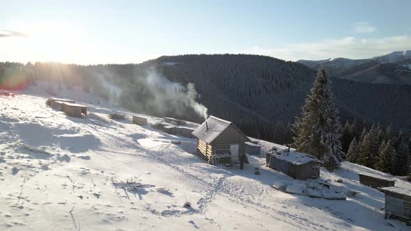 Flying Over Log Cabin Hut With Smoke Coming Out of a Chimney