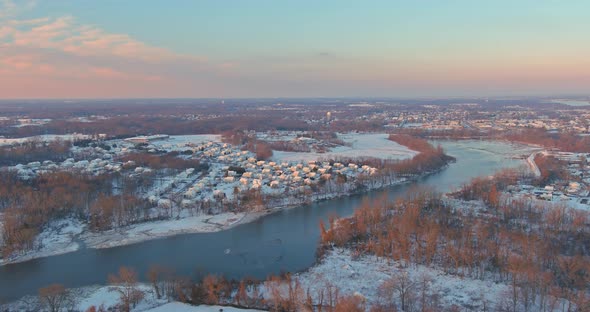 Aerial View of Amazing Winter Sunset in Suburb City with Snow Covered Residential Quarters By the alt
