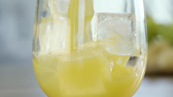 Orange Juice Pouring On Ice Cubes