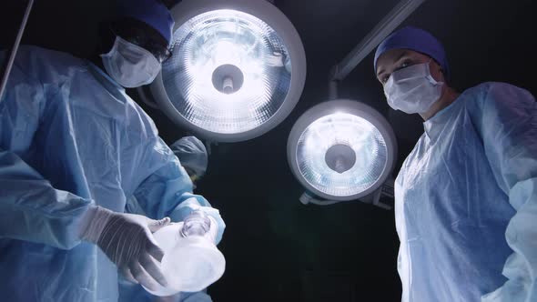 Anesthetist and his assistants putting mask on patient