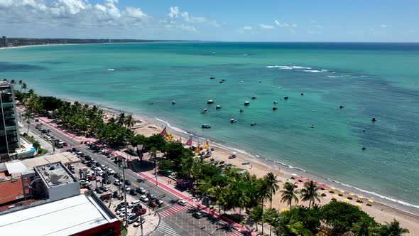 Aerial panning shot of turquoise water beach at Maceio Alagoas Brazil. alt